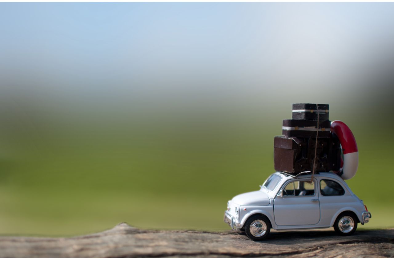 petite voiture avec des bagages sur le toit prête pour un road trip